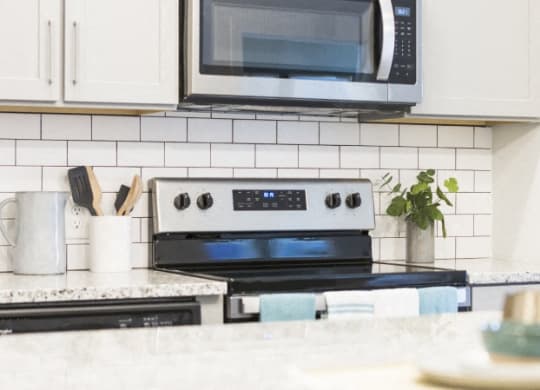 a white kitchen with a stove and a microwave