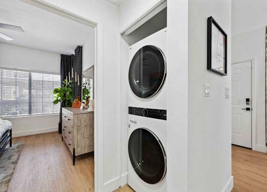 A modern laundry room with a washer and dryer built into the wall.