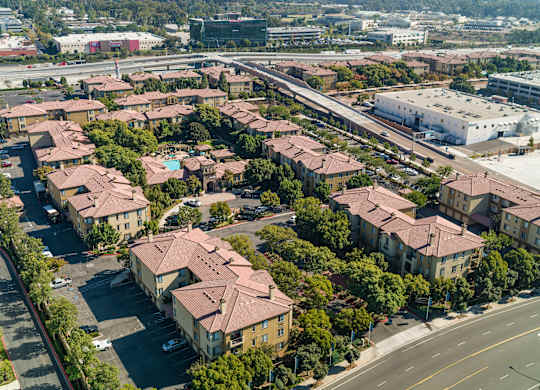 A large apartment complex with a parking lot in front.