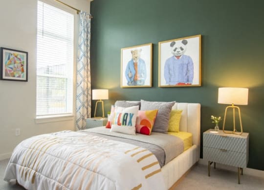 a bedroom with a bed and two paintings on the wall
