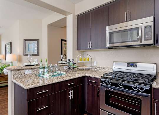 A kitchen with brown cabinets and a granite countertop.