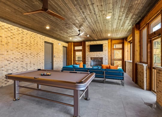 gather around the pool table to play a game of pool