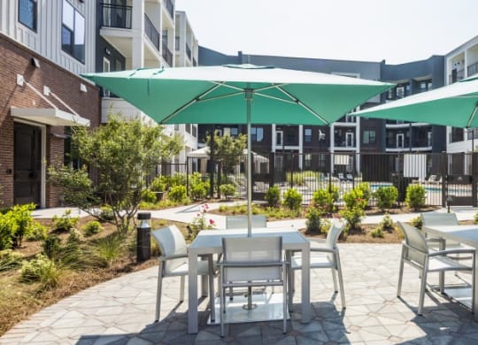 a patio with tables and chairs and umbrellas