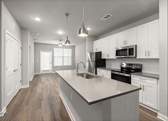 A modern kitchen with white cabinets and a large island.