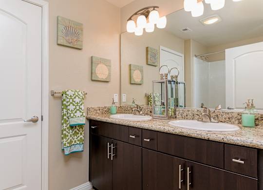 A bathroom with brown cabinets and a white door.