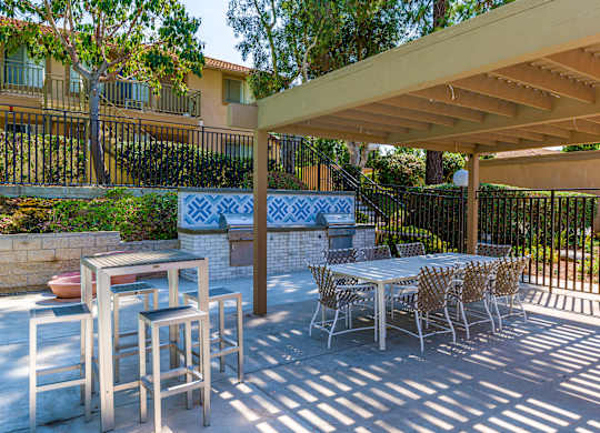 A patio with a table and chairs under a roof.
