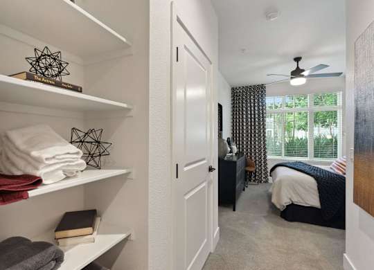 A white shelf with towels and a book on it.