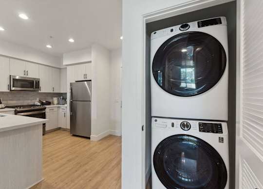 A white washing machine is in a white door.
