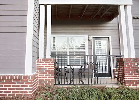 A house with a grey siding and a black metal railing.