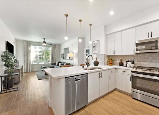 A modern kitchen with white cabinets and stainless steel appliances.