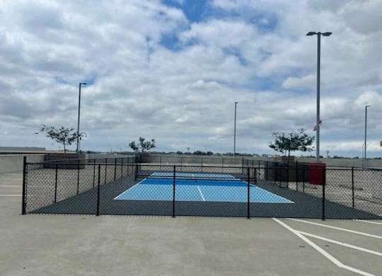 a rooftop pickleball court with a fence around it