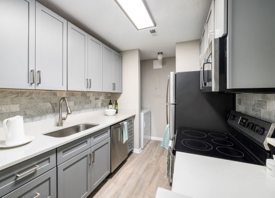 an empty kitchen with white cabinets and a black stove and refrigerator at View at Lake Lynn, Raleigh North Carolina