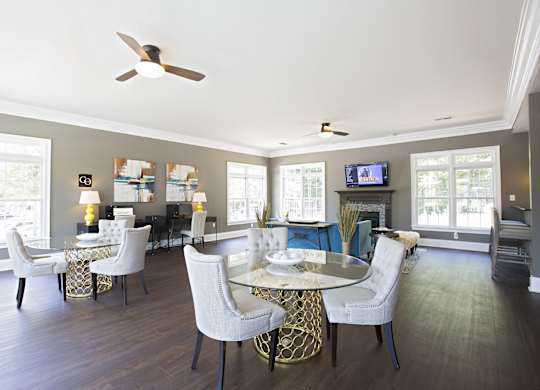 Resident clubhouse with tables and chairs at Peachtree Landing Fairburn, GA apartment rentals.