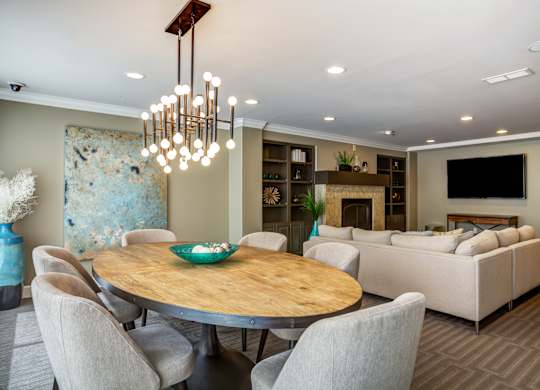 A modern dining room with a wooden table and chairs.