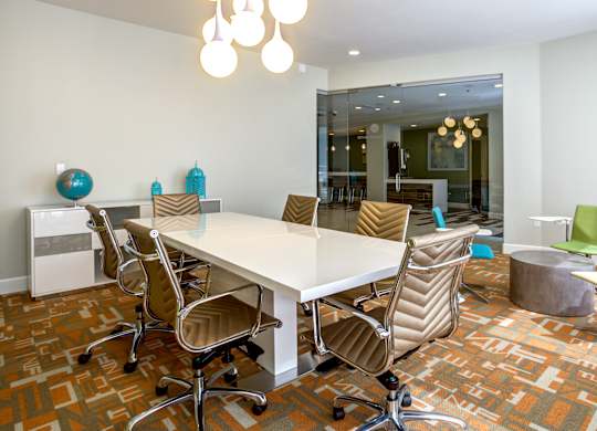 A conference room with a white table and chairs.