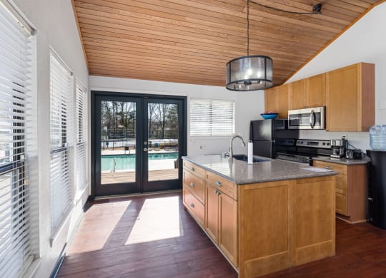 a kitchen with a large island and a door to a swimming pool