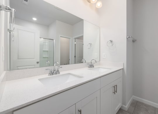 a white bathroom with two sinks and a large mirror