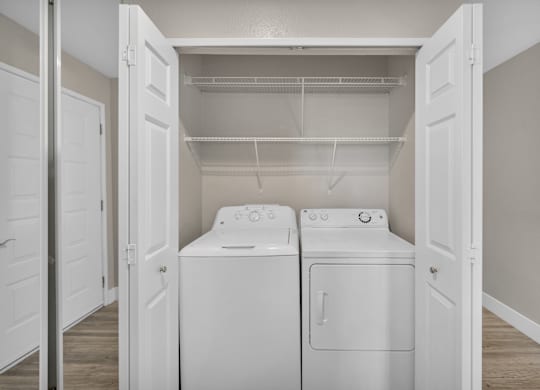 an empty laundry room with two washes and a dryer