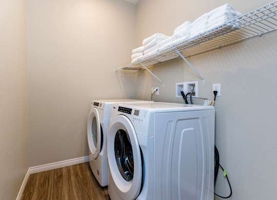 A white dryer and washer are in a small laundry room.