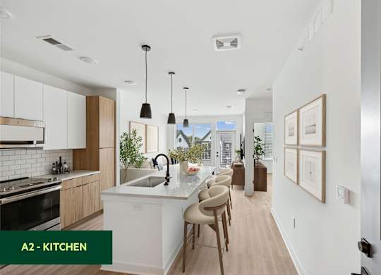 A modern kitchen with a large island and pendant lights.