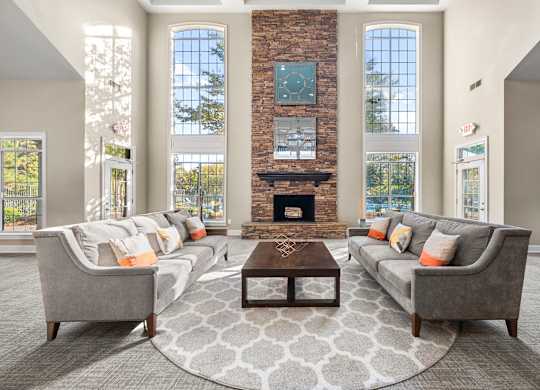 a living room with couches and a table in front of a fireplace