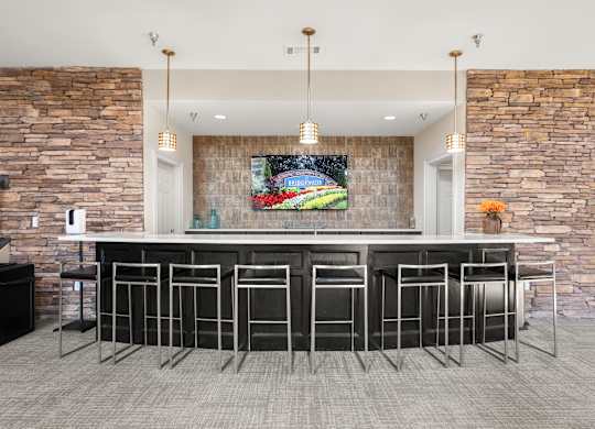 a bar with stools in a kitchen with stone walls