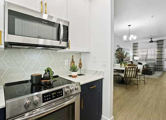 A modern kitchen with a stove top oven and microwave above it.