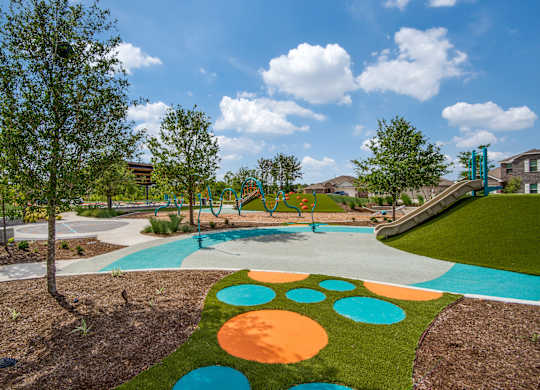 A playground with a slide and a tree.