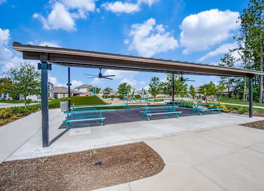 A park with a blue bench and a white canopy.