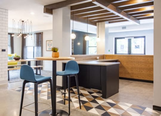 a kitchen and dining area with blue chairs and a table