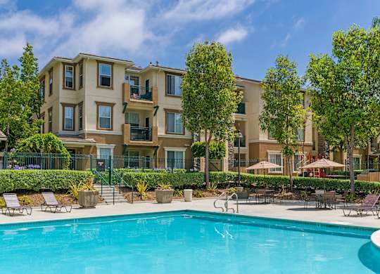 A swimming pool in front of apartment buildings.