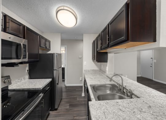 a kitchen with granite counter tops and black appliances
