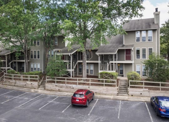 the apartment building with cars parked in a parking lot