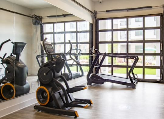 a workout room with weights in front of a window