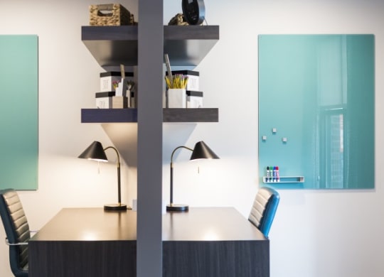 a conference room with a table and chairs and two lamps