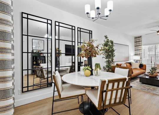 A dining room with a white table and chairs.