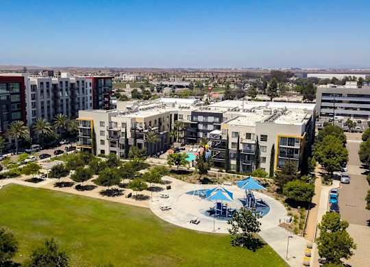A large building complex with a pool in the middle of a grassy area.