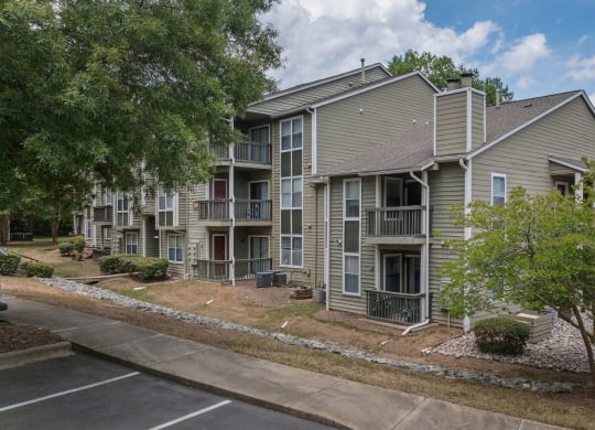 exterior view of an apartment building with sidewalks and trees
