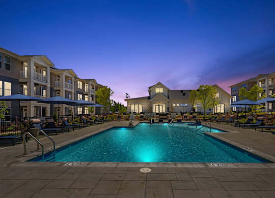 A swimming pool in a residential area surrounded by apartment buildings.