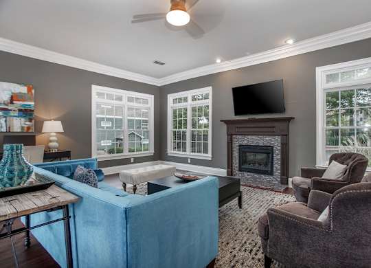 A living room with a blue couch and a fireplace.