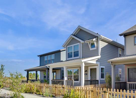 a blue house with white trim and a wooden fence
