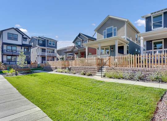 a row of houses with a yard and a sidewalk