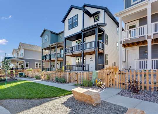 an exterior view of an apartment building with a sidewalk and grass