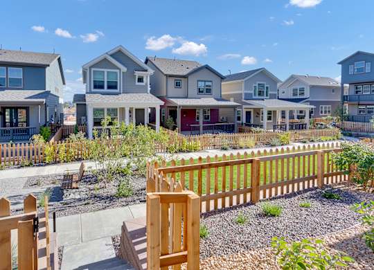 a row of houses with a yard and a wooden fence