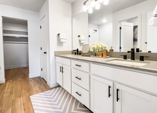 a bathroom with white cabinets and a striped rug