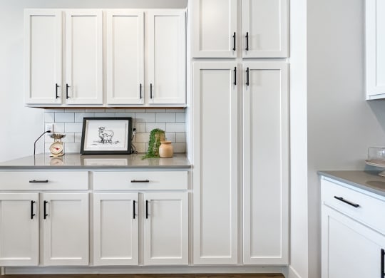 a white kitchen with white cabinets and a white countertop