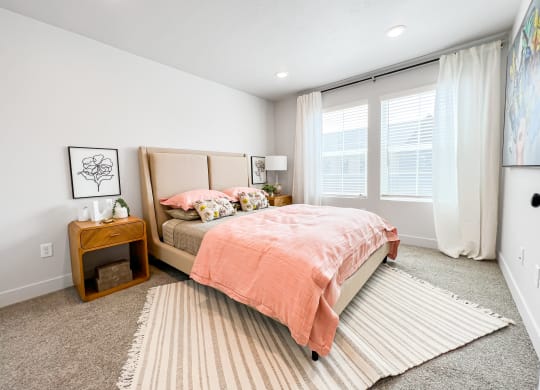 a bedroom with a bed and two windows