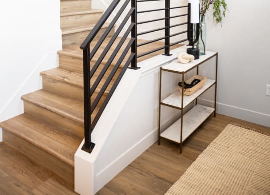 a stairway in a home with white walls and a black tire on the wall