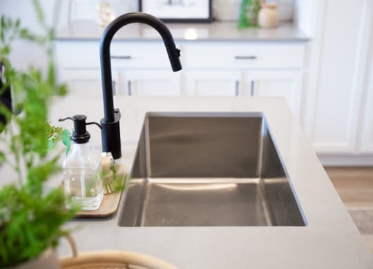 a kitchen sink with a black faucet