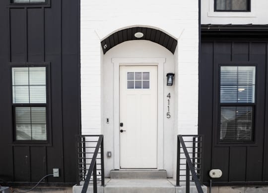 a black and white photo of a white house with a white door